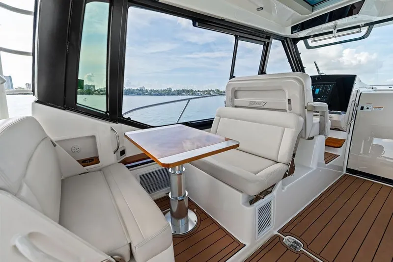 Slide: The Image of 2024 Boston Whaler 405 Conquest interior with elegant seating and wooden table. - 39
