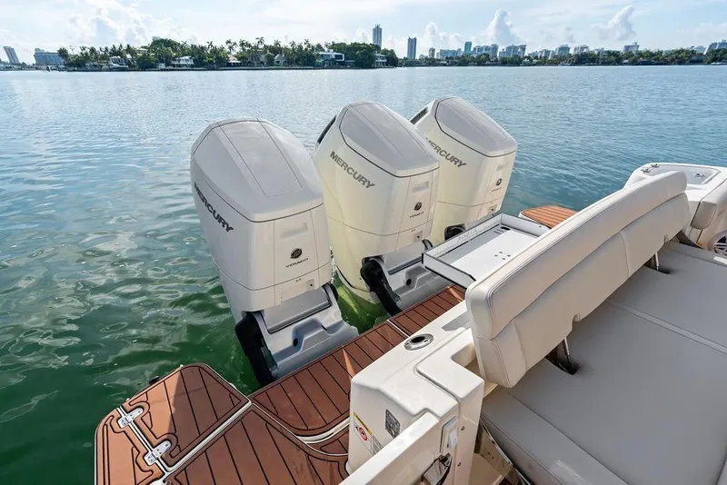 Slide: The Image of 2024 Boston Whaler 405 Conquest with triple Mercury outboard engines on calm water. - 49