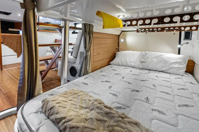 Slide: The Image of Interior cabin of 2024 Boston Whaler 405 Conquest, featuring a cozy bed and wooden accents. - 63