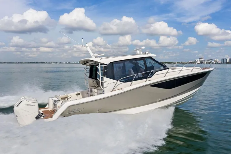 Slide: The Image of 2024 Boston Whaler 405 Conquest cruising on water under a partly cloudy sky. - 14