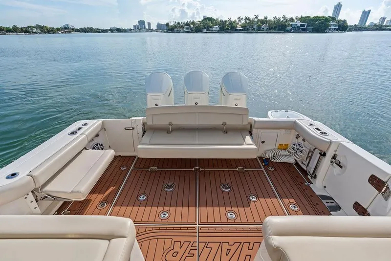 Slide: The Image of 2024 Boston Whaler 405 Conquest boat deck with seating and scenic waterfront view. - 41