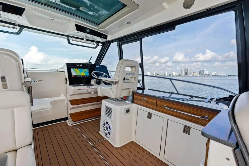 Slide: The Image of Interior view of 2024 Boston Whaler 405 Conquest boat with modern helm and ocean backdrop. - 36