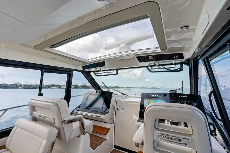 Slide: The Image of Interior view of 2024 Boston Whaler 405 Conquest boat cockpit with navigation screens. - 26