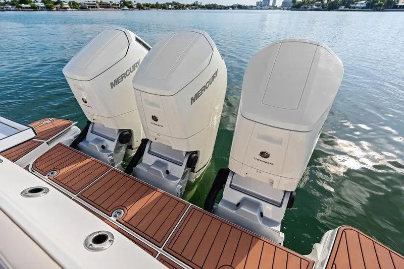 Slide: The Image of 2024 Boston Whaler 405 Conquest with triple Mercury outboard engines on teak deck. - 50