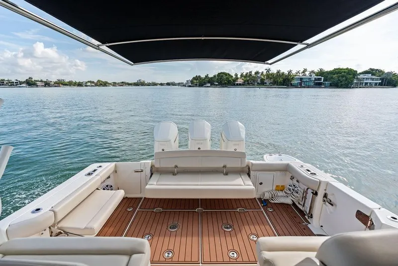 Slide: The Image of 2024 Boston Whaler 405 Conquest boat deck with seating, overlooking serene water and shoreline. - 46