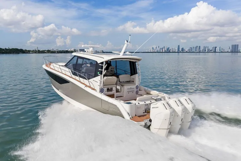 Slide: The Image of 2024 Boston Whaler 405 Conquest cruising on water with city skyline in background. - 18