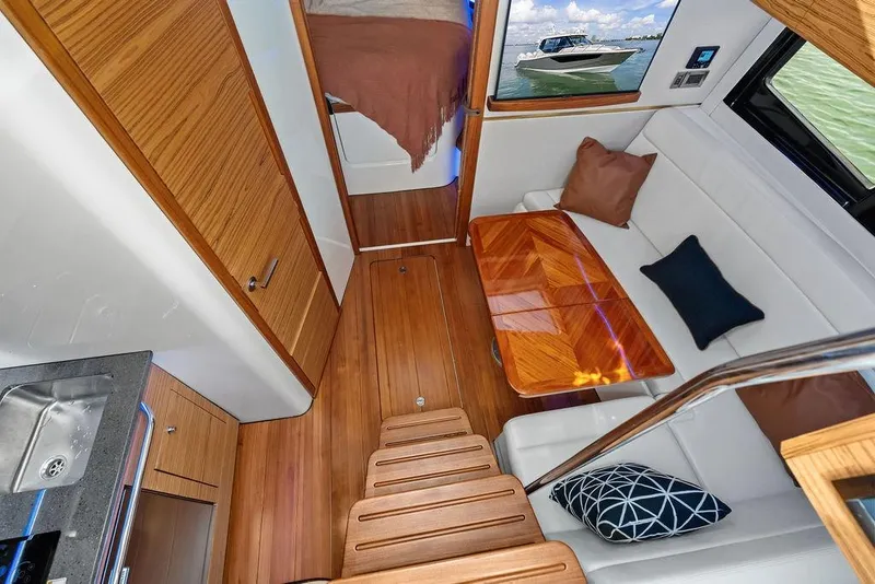 Slide: The Image of 2024 Boston Whaler 405 Conquest interior with wooden flooring and cozy seating area. - 51