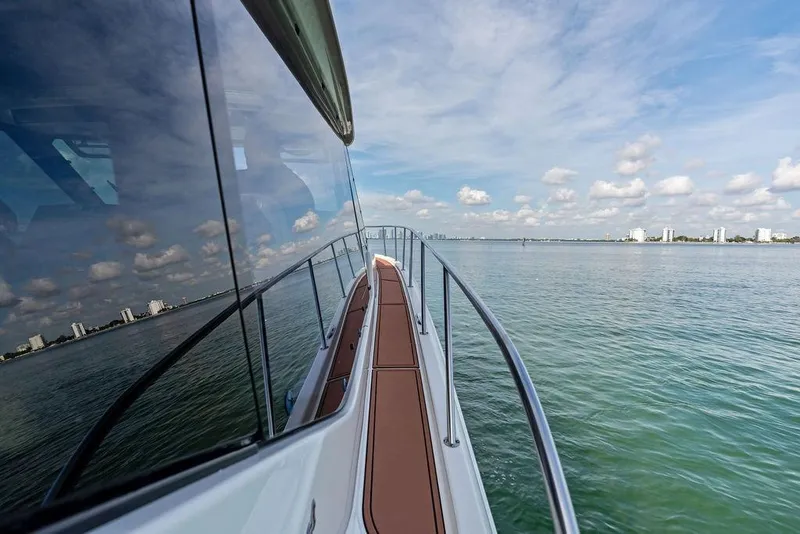 Slide: The Image of 2024 Boston Whaler 405 Conquest yacht cruising on calm waters under a partly cloudy sky. - 25