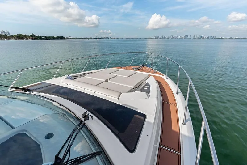 Slide: The Image of 2024 Boston Whaler 405 Conquest cruising on calm waters with city skyline view. - 21