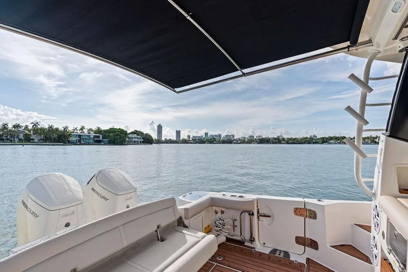 Slide: The Image of Boston Whaler 405 Conquest 2024, rear deck view with Mercury engines, scenic waterfront. - 47