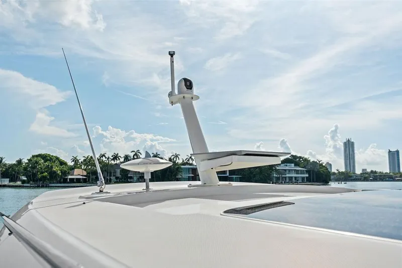 Slide: The Image of 2024 Boston Whaler 405 Conquest boat deck with radar and antenna, scenic waterfront view. - 24