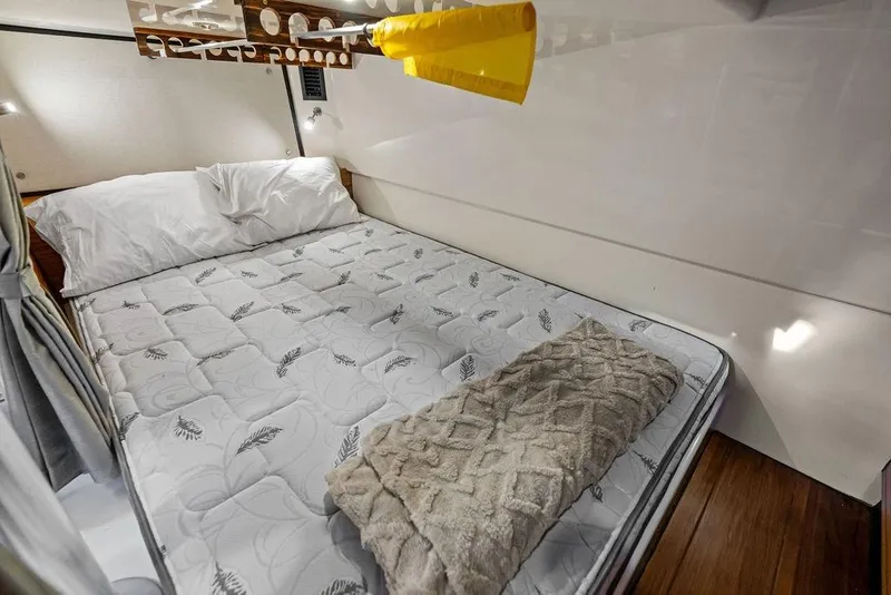 Slide: The Image of Cozy cabin bed in 2024 Boston Whaler 405 Conquest, featuring plush bedding and modern design. - 62