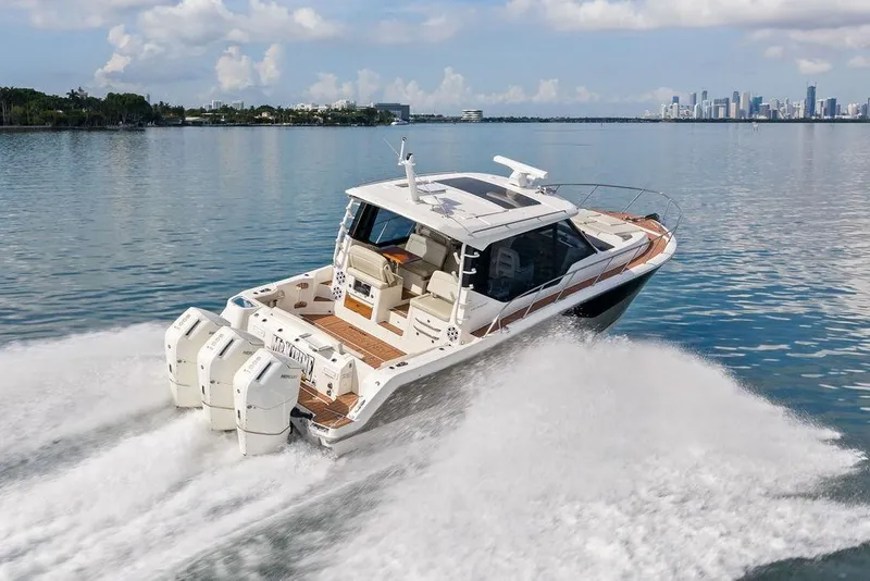 Slide: The Image of 2024 Boston Whaler 405 Conquest cruising on calm waters near a city skyline. - 16