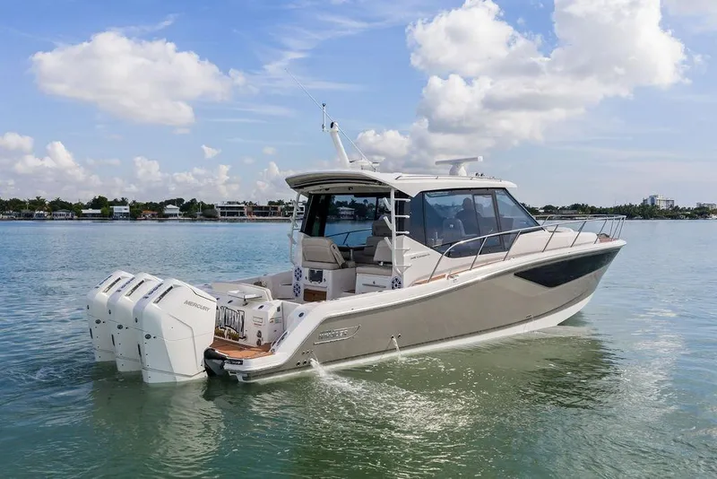 Slide: The Image of 2024 Boston Whaler 405 Conquest boat cruising on calm waters under a clear sky. - 8