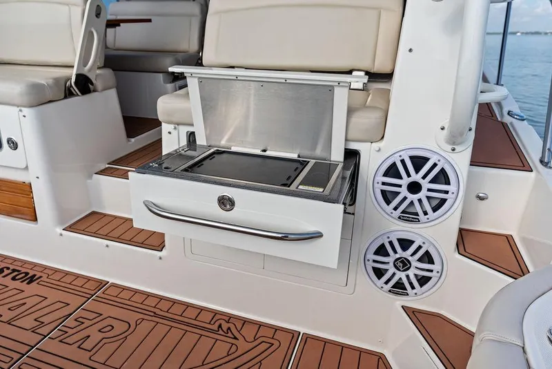 Slide: The Image of 2024 Boston Whaler 405 Conquest interior with seating, speakers, and storage drawer. - 45