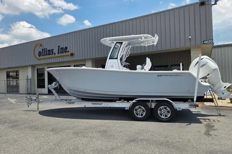 Slide: The Image of 2026 Sportsman Open 232 Center Console boat on trailer outside Collins Inc. building. - 1