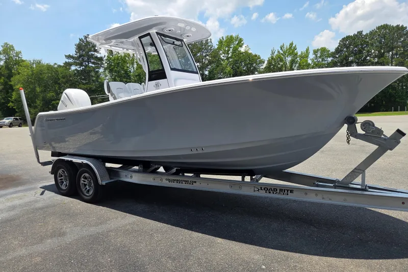 Slide: The Image of 2026 Sportsman Open 232 Center Console boat on trailer, parked outdoors under a clear sky. - 5