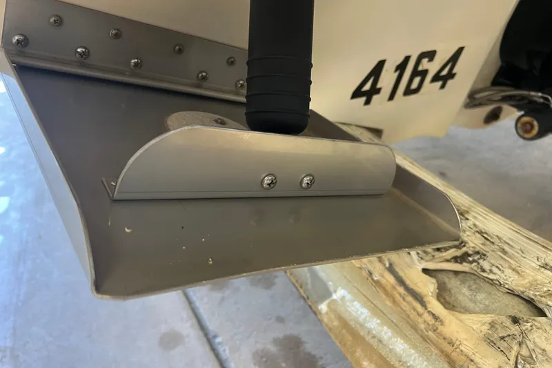 Slide: The Image of Close-up of a 2004 Sea Ray 270 Sundeck boat's trim tab with visible screws. - 9