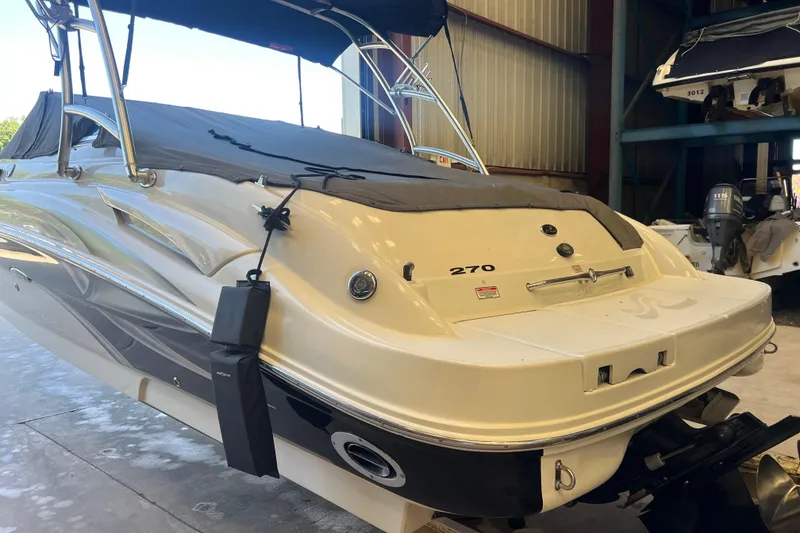 Slide: The Image of 2004 Sea Ray 270 Sundeck boat in storage, featuring sleek design and covered deck. - 7