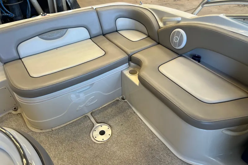 Slide: The Image of 2004 Sea Ray 270 Sundeck interior seating with gray upholstery and built-in speaker. - 24
