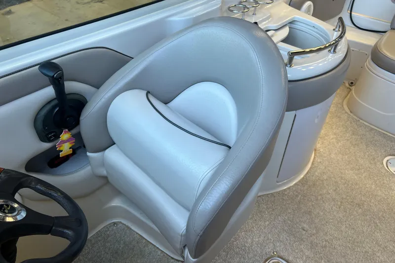 Slide: The Image of Interior of a 2004 Sea Ray 270 Sundeck boat, featuring a plush captain's chair and control panel. - 12