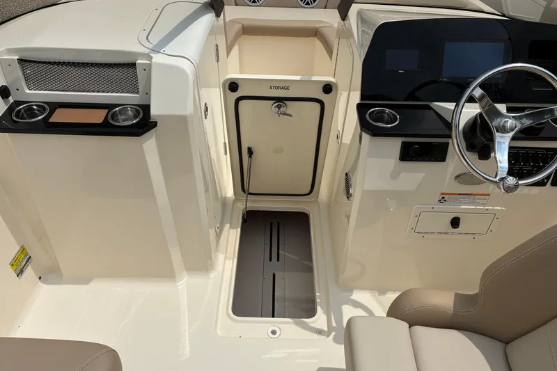 Slide: The Image of Interior view of 2026 Scout 215 Dorado boat, featuring steering wheel and storage compartment. - 5