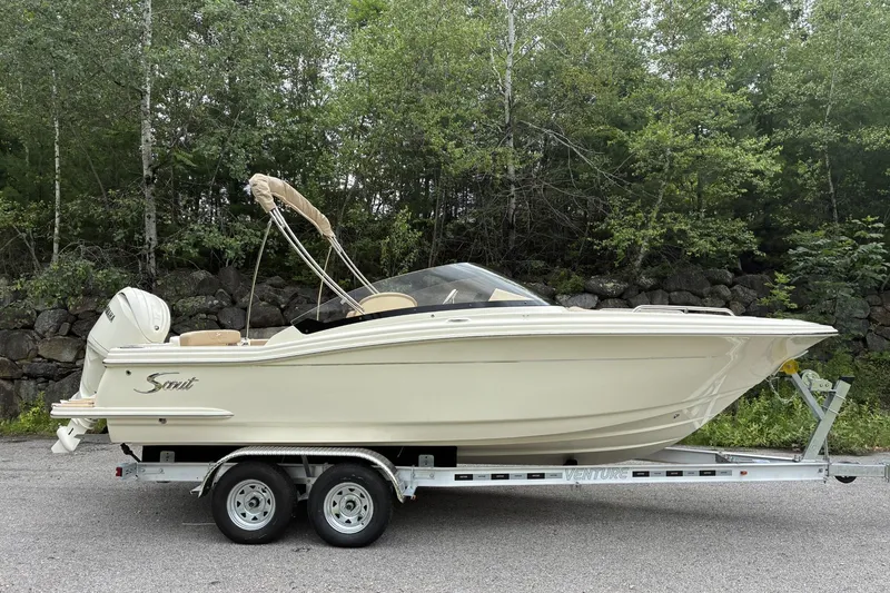 The Image of 2026 Scout 215 Dorado boat on trailer, surrounded by lush greenery. - 0