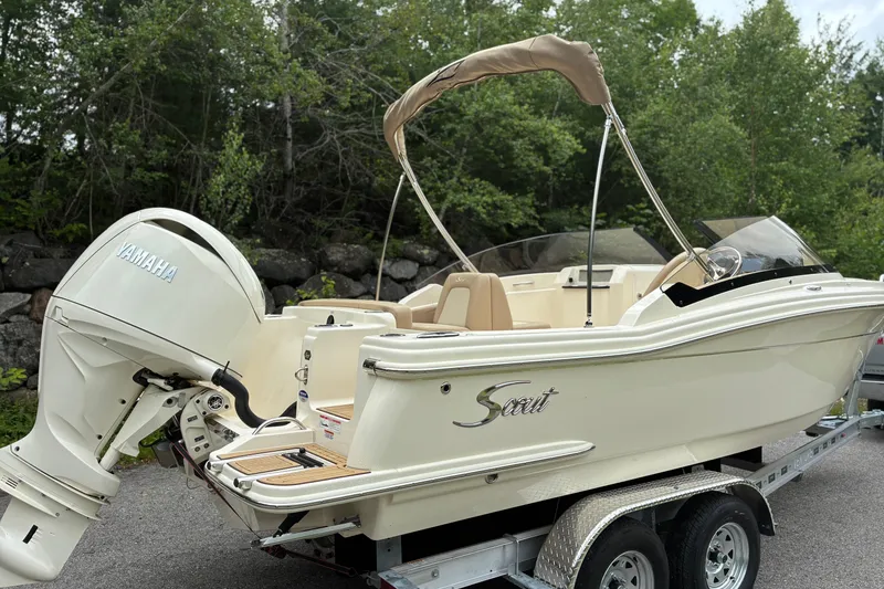 Slide: The Image of 2026 Scout 215 Dorado boat with Yamaha engine on trailer, surrounded by trees. - 2