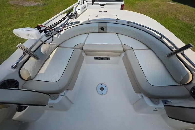 Slide: The Image of 2021 Carolina Skiff 21 Ultra Elite boat interior with cushioned seating and trolling motor. - 2