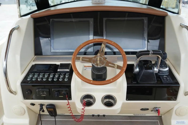 Slide: The Image of Helm of 2016 Chris-Craft Catalina 34 with dual screens and wooden steering wheel. - 24