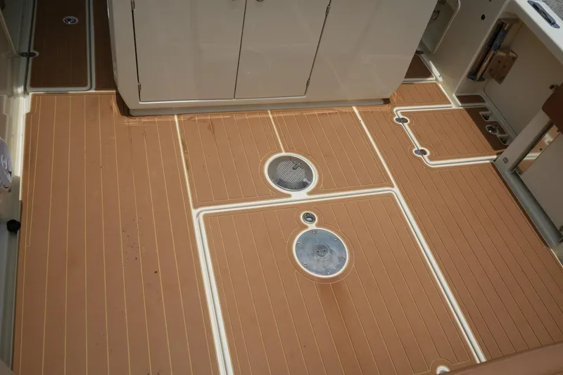 Slide: The Image of 2016 Chris-Craft Catalina 34 boat deck with teak-style flooring and storage compartments. - 16
