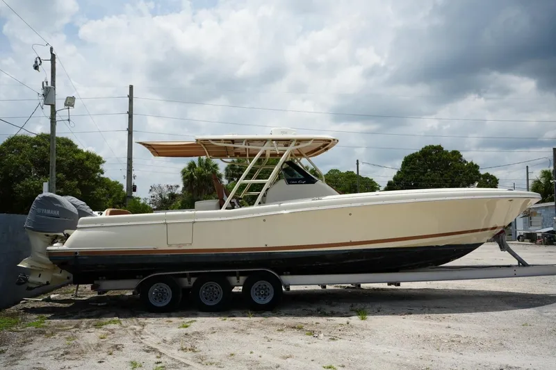The Image of 2016 Chris-Craft Catalina 34 boat on trailer, parked outdoors under cloudy sky. - 1