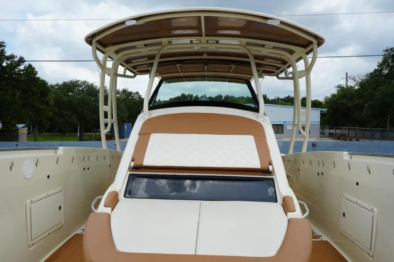 Slide: The Image of 2016 Chris-Craft Catalina 34 boat with tan seating and canopy, docked outdoors. - 29
