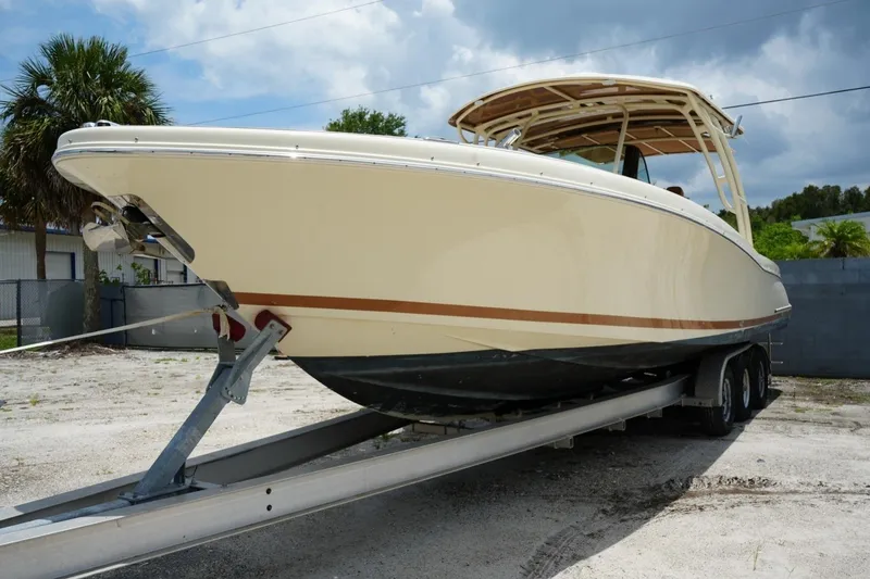 Slide: The Image of 2016 Chris-Craft Catalina 34 boat on trailer, parked outdoors under cloudy sky. - 6