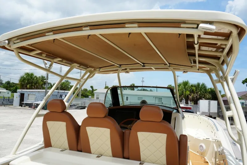 Slide: The Image of 2016 Chris-Craft Catalina 34 boat interior with tan seating and overhead canopy. - 21