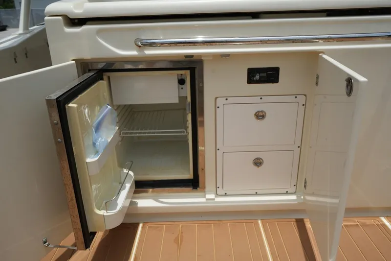 Slide: The Image of 2016 Chris-Craft Catalina 34 boat interior with open fridge and storage compartments. - 17