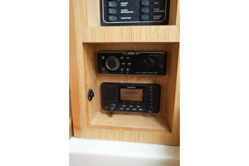 Slide: The Image of 2016 Chris-Craft Catalina 34 interior electronics panel with Fusion and Garmin devices. - 34