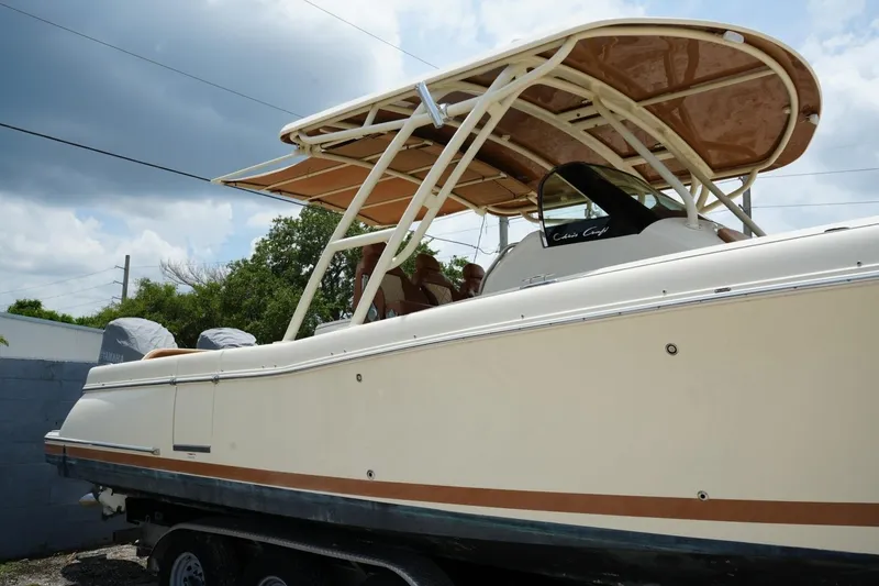 Slide: The Image of 2016 Chris-Craft Catalina 34 boat with canopy, parked on a trailer under cloudy skies. - 11