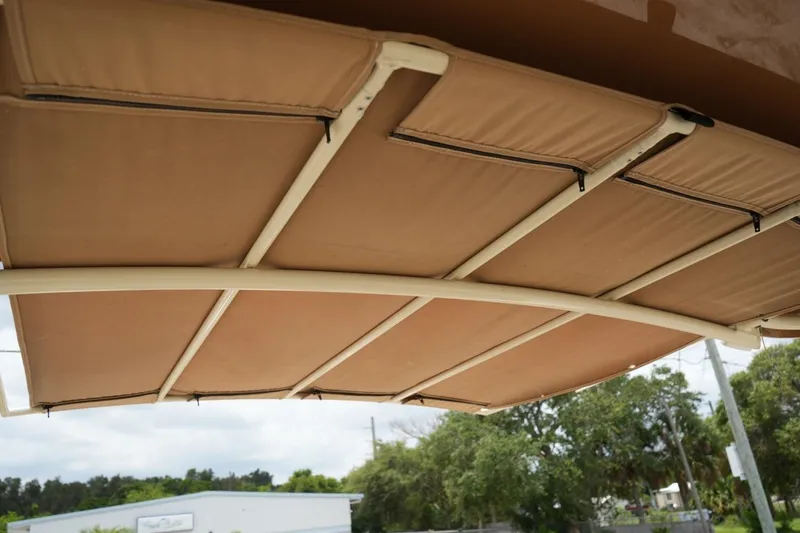 Slide: The Image of 2016 Chris-Craft Catalina 34 boat canopy, beige fabric with sturdy frame, outdoor setting. - 26