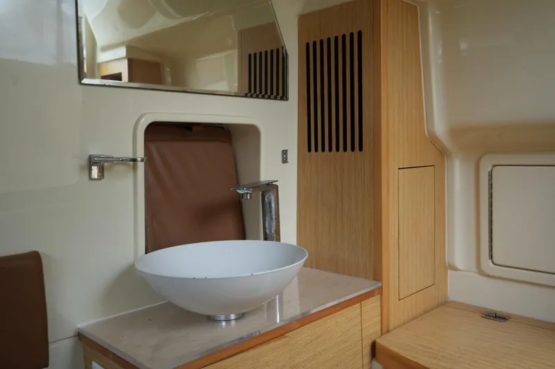 Slide: The Image of Interior of 2016 Chris-Craft Catalina 34 featuring a modern sink and wooden cabinetry. - 38