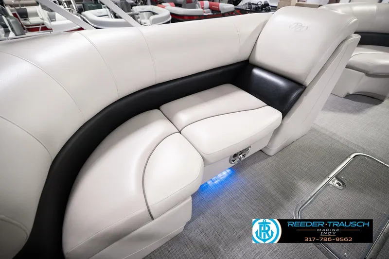 Slide: The Image of 2018 Manitou 23 Oasis RF VP boat interior with plush seating and ambient lighting. - 33