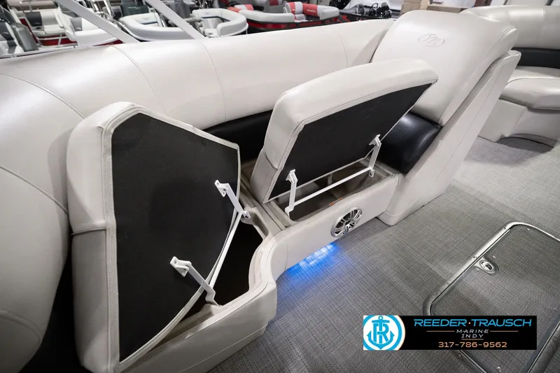 Slide: The Image of 2018 Manitou 23 Oasis RF VP boat interior with open storage compartments and speaker. - 34