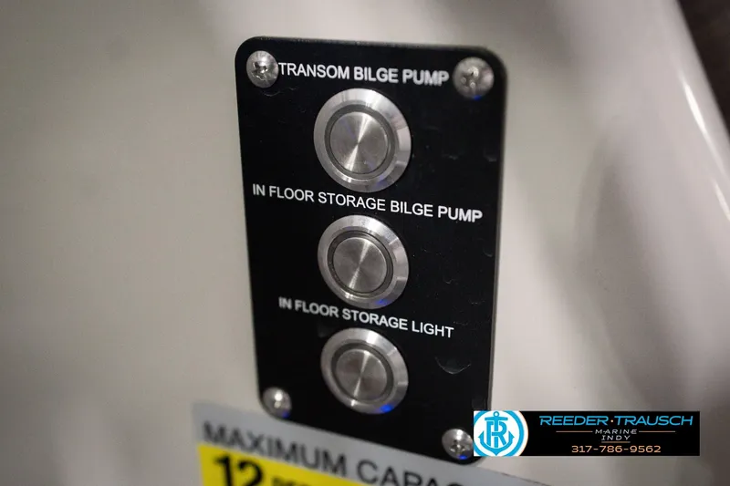 Slide: The Image of Control panel with buttons for bilge pumps and storage light on a 2018 Manitou 23 Oasis RF VP. - 51