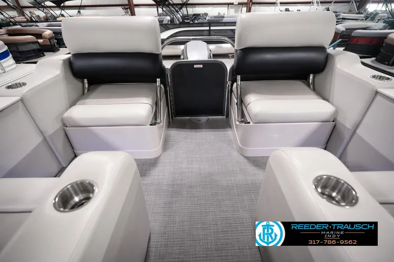 Slide: The Image of 2018 Manitou 23 Oasis RF VP boat interior with plush seating and cup holders. - 37