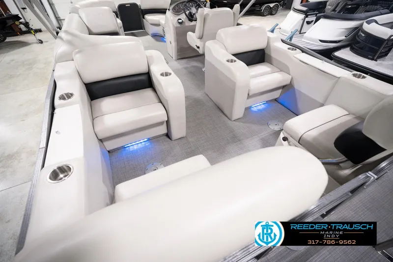 Slide: The Image of 2018 Manitou 23 Oasis RF VP pontoon boat interior with plush seating and ambient lighting. - 17