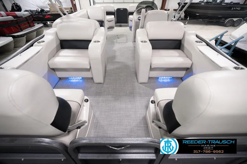 Slide: The Image of 2018 Manitou 23 Oasis RF VP pontoon boat interior with plush seating and ambient lighting. - 22