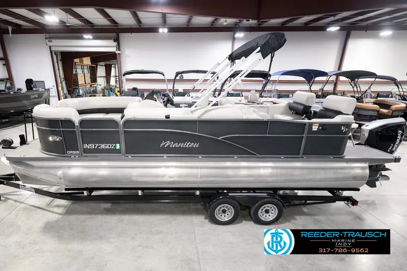 The Image of 2018 Manitou 23 Oasis RF VP pontoon boat in showroom, side view on trailer. - 0
