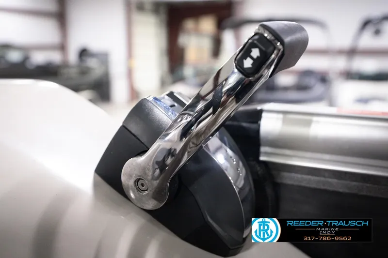 Slide: The Image of Close-up of a 2018 Manitou 23 Oasis RF VP boat throttle lever in a showroom. - 53
