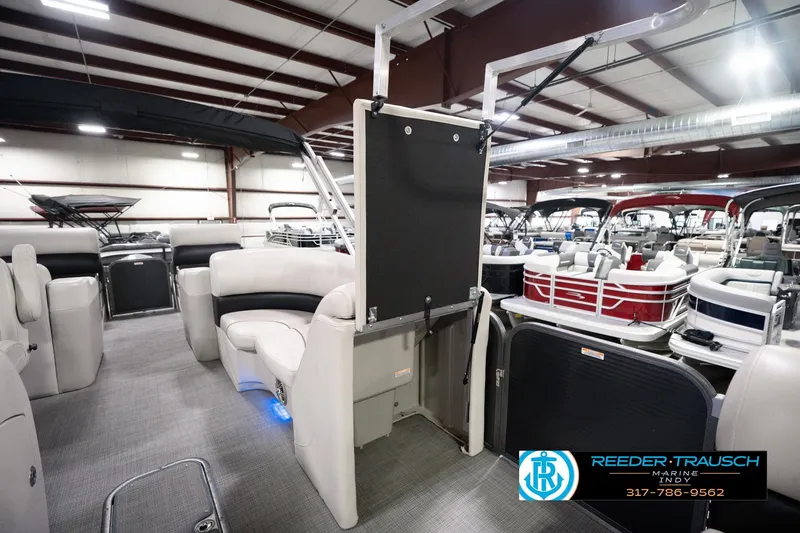 Slide: The Image of Interior view of a 2018 Manitou 23 Oasis RF VP pontoon boat in a showroom. - 32