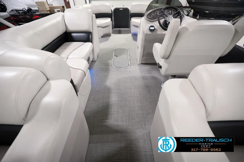 Slide: The Image of 2018 Manitou 23 Oasis RF VP boat interior with plush seating and modern dashboard. - 24